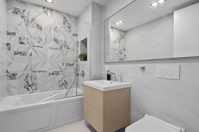 bathroom featuring tile walls, bathing tub / shower combination, vanity, and recessed lighting