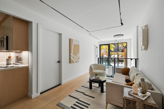 living area with light wood-style flooring and baseboards