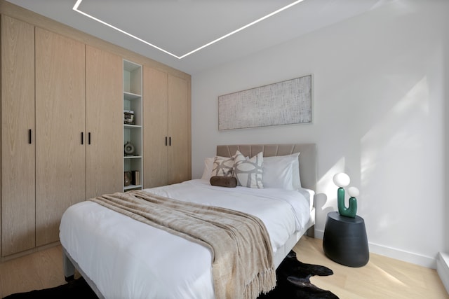 bedroom with baseboards and wood finished floors