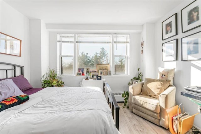 bedroom featuring a baseboard radiator and light hardwood / wood-style flooring