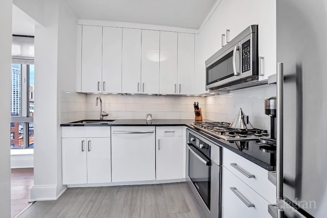 kitchen with sink, white cabinetry, appliances with stainless steel finishes, and plenty of natural light