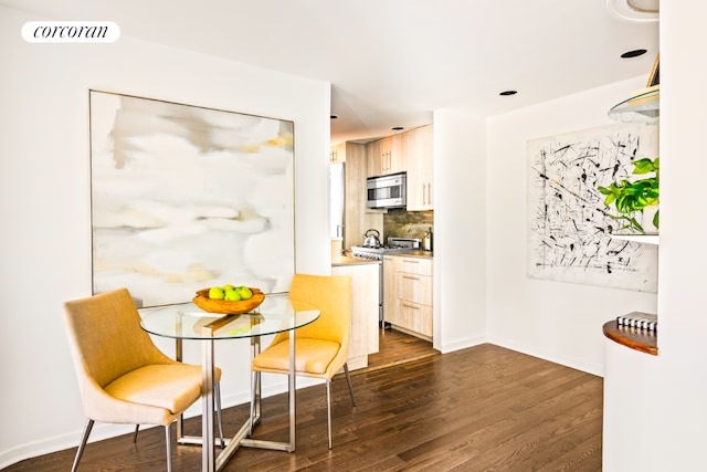 kitchen featuring backsplash, light brown cabinets, dark hardwood / wood-style floors, and stainless steel appliances