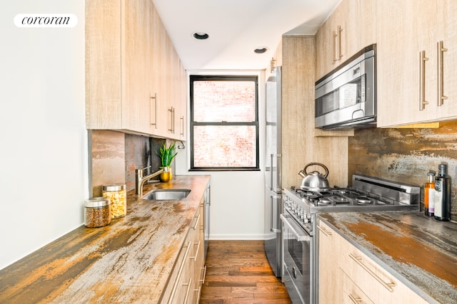 kitchen with premium appliances, dark hardwood / wood-style floors, light brown cabinets, tasteful backsplash, and sink