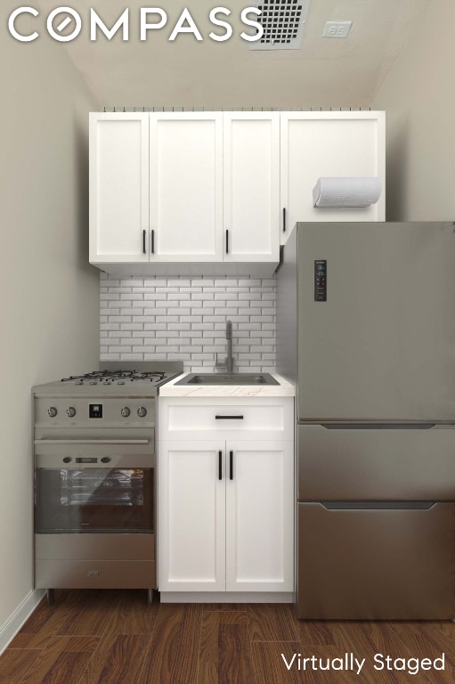 kitchen with stainless steel appliances, white cabinetry, tasteful backsplash, and sink