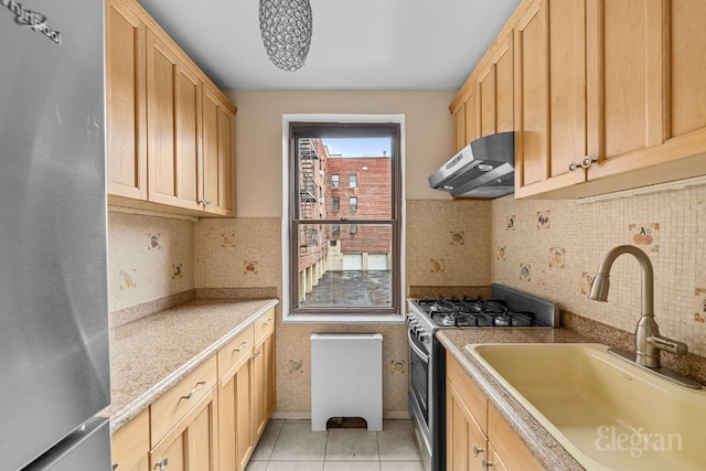 kitchen featuring backsplash, sink, appliances with stainless steel finishes, light brown cabinets, and light tile patterned floors