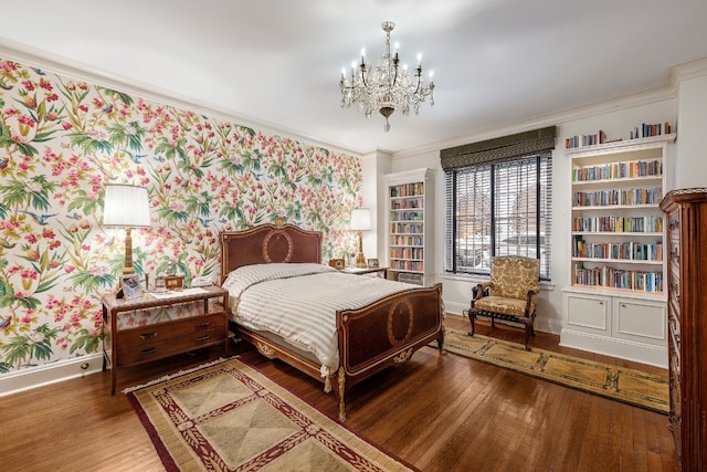 bedroom featuring hardwood / wood-style flooring, crown molding, and an inviting chandelier