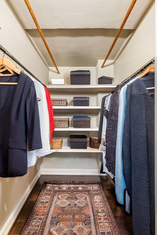 walk in closet with dark wood-type flooring