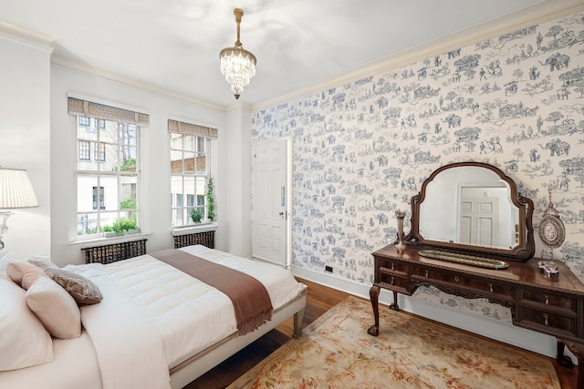 bedroom with hardwood / wood-style flooring, radiator, ornamental molding, and an inviting chandelier