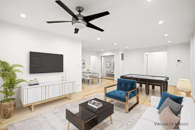 living room featuring light wood finished floors, baseboards, a ceiling fan, and recessed lighting