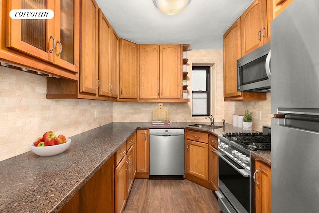 kitchen with stainless steel appliances, dark wood-style flooring, a sink, dark stone counters, and open shelves