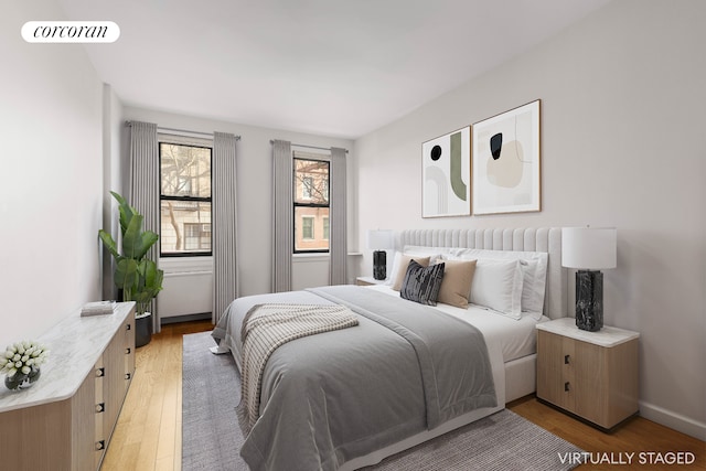 bedroom featuring visible vents, light wood-type flooring, and baseboards