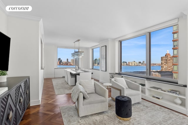 living room with a water view, ornamental molding, visible vents, baseboards, and a view of city