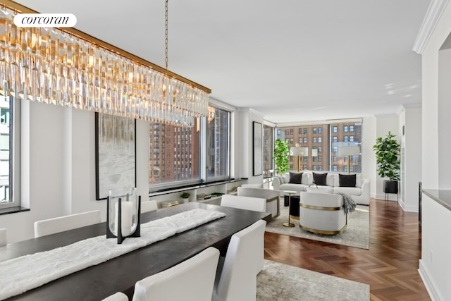 dining room with a chandelier, crown molding, and baseboards