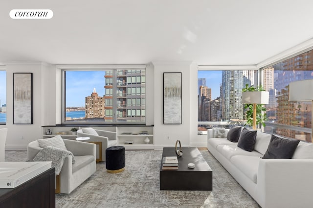 living room with baseboards, visible vents, a city view, and expansive windows