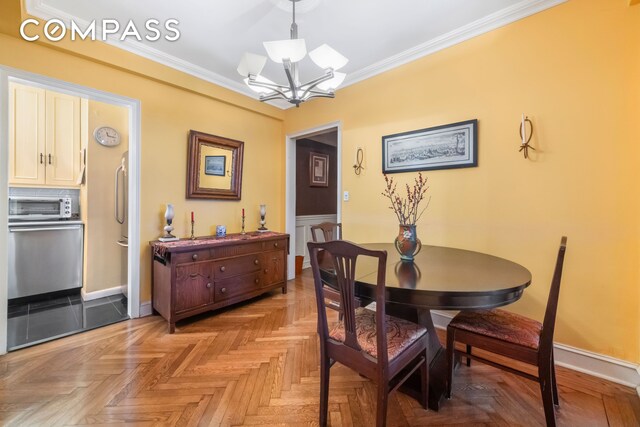 dining area featuring light parquet flooring, ornamental molding, and a chandelier