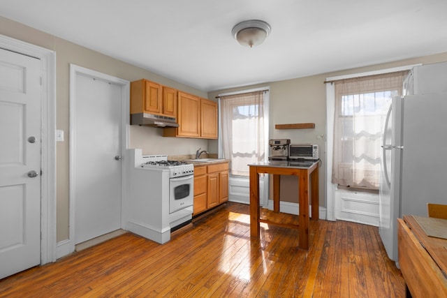 464 5th St, New York City, NY 11215 - kitchen featuring white appliances, under cabinet range hood, a sink, dark wood-type flooring, and light countertops