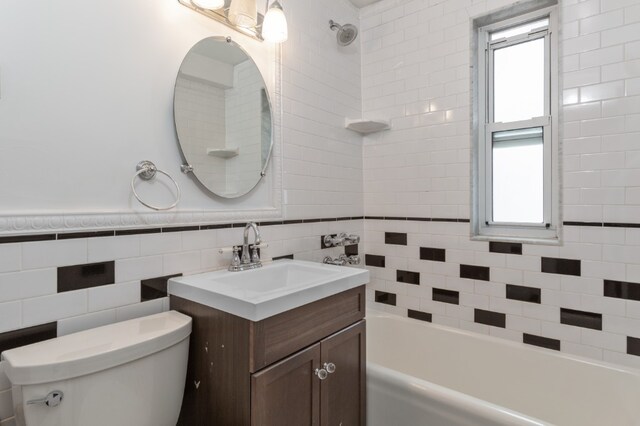 full bathroom with tile walls, plenty of natural light, vanity, and toilet