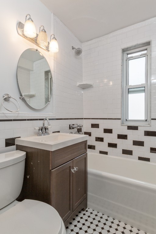 full bathroom with tile patterned flooring, shower / washtub combination, toilet, vanity, and tile walls
