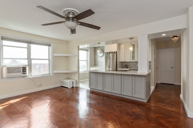 kitchen featuring baseboards, cooling unit, stainless steel fridge, hanging light fixtures, and ceiling fan