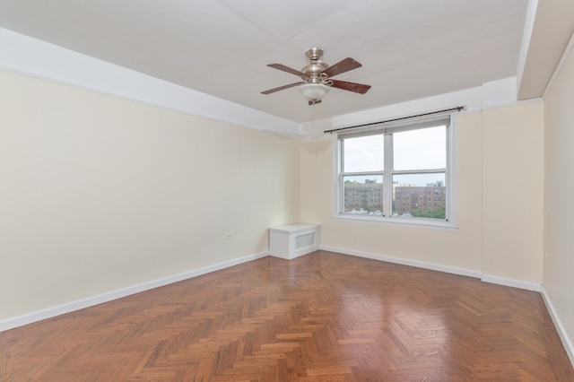 unfurnished room featuring ceiling fan and baseboards