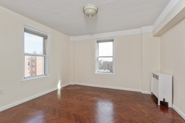 unfurnished room with radiator and baseboards