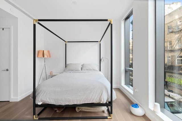 bedroom featuring hardwood / wood-style floors and multiple windows