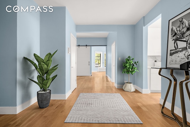 hallway featuring light wood-style floors and baseboards