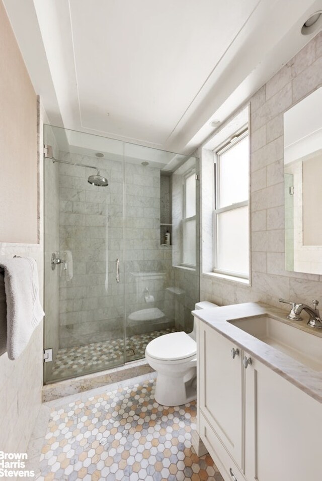8 E 96th St Unit 14C, New York City, NY 10128 - full bathroom with toilet, vanity, a stall shower, and tile walls
