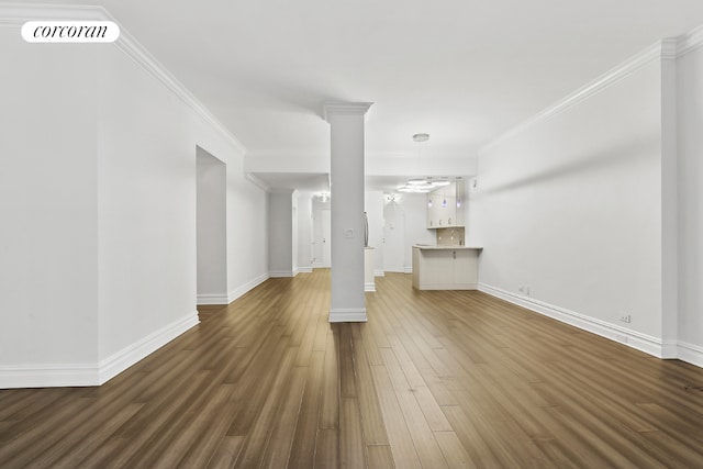 unfurnished living room with wood-type flooring and crown molding