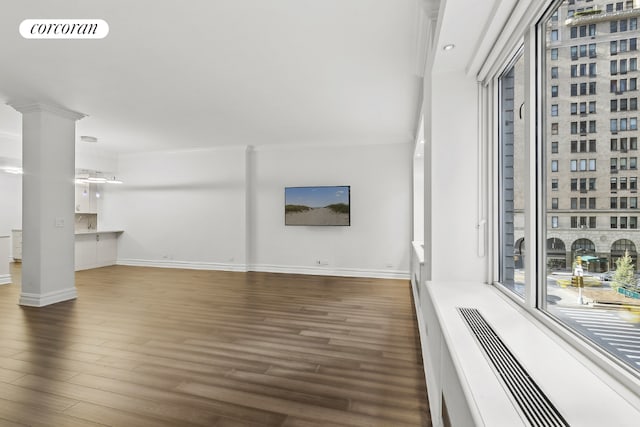 unfurnished living room with dark wood-type flooring and ornamental molding