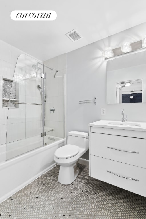 full bathroom with toilet, tile patterned floors, vanity, and shower / bath combination with glass door