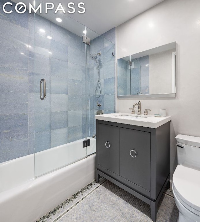 full bathroom with tile patterned floors, toilet, vanity, and combined bath / shower with glass door