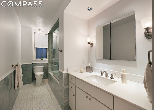 bathroom featuring toilet, tile walls, tile patterned floors, and vanity