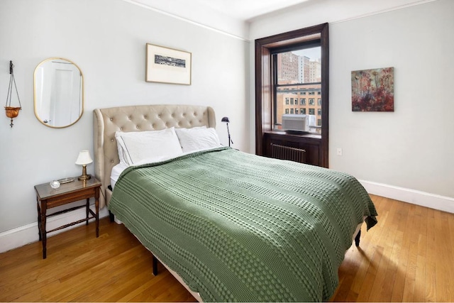 bedroom with hardwood / wood-style flooring and radiator