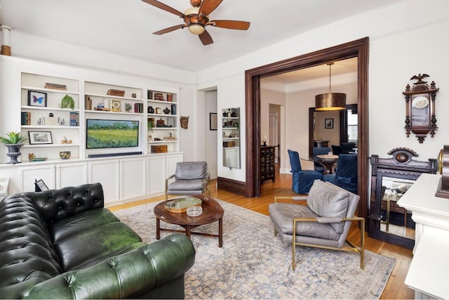 living room with light hardwood / wood-style flooring and ceiling fan