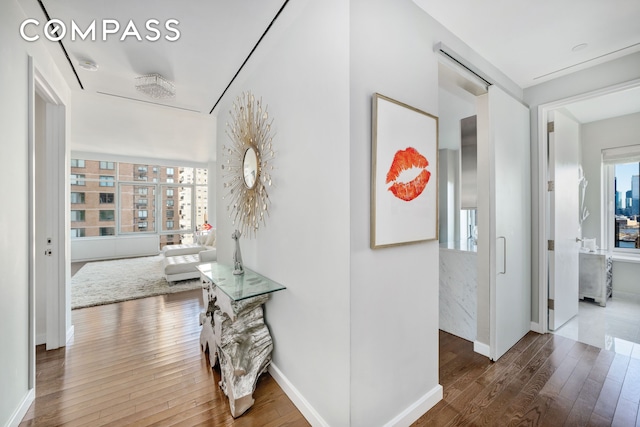 hall with wood-type flooring and baseboards