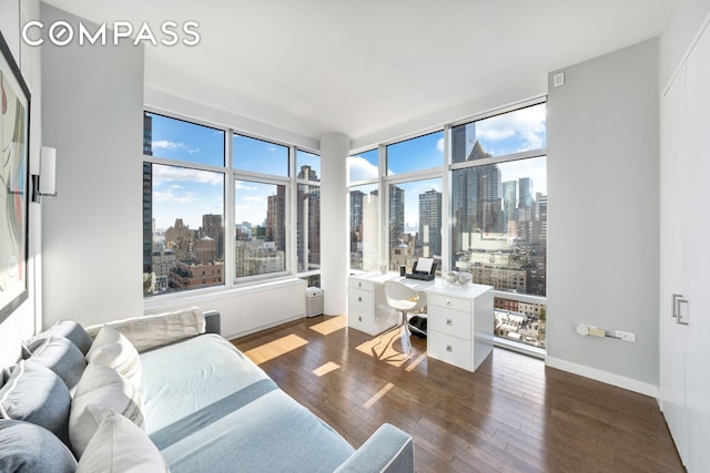 home office with a view of city, dark wood-style flooring, and baseboards