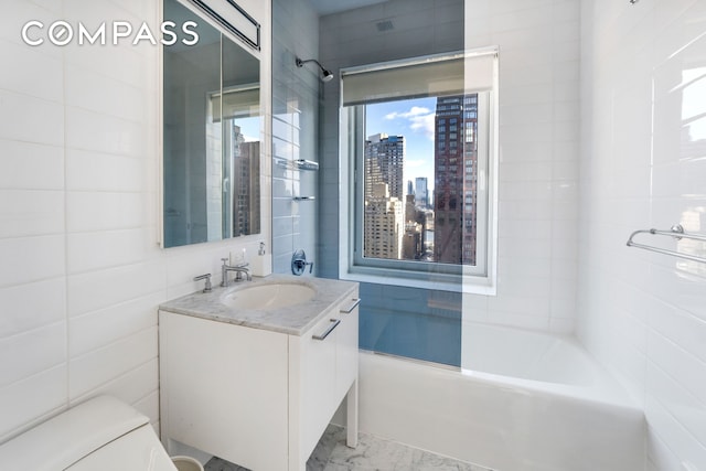 full bathroom featuring a view of city, marble finish floor, tile walls, toilet, and vanity