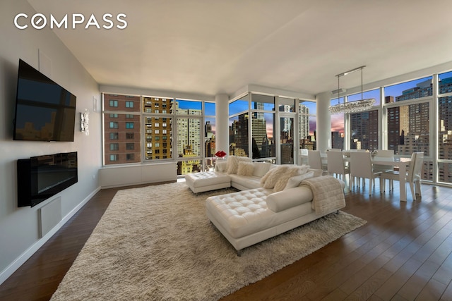 living room with a fireplace, dark wood-style floors, baseboards, floor to ceiling windows, and a view of city