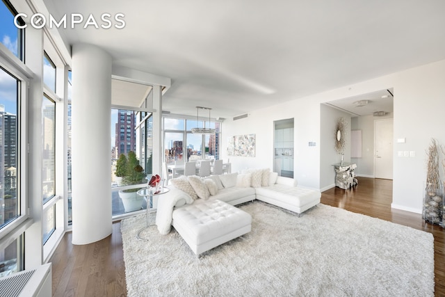 living room featuring plenty of natural light, dark wood-style flooring, a city view, and baseboards
