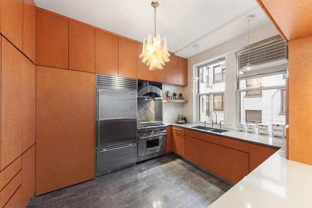 kitchen with sink, decorative backsplash, hanging light fixtures, high end appliances, and exhaust hood