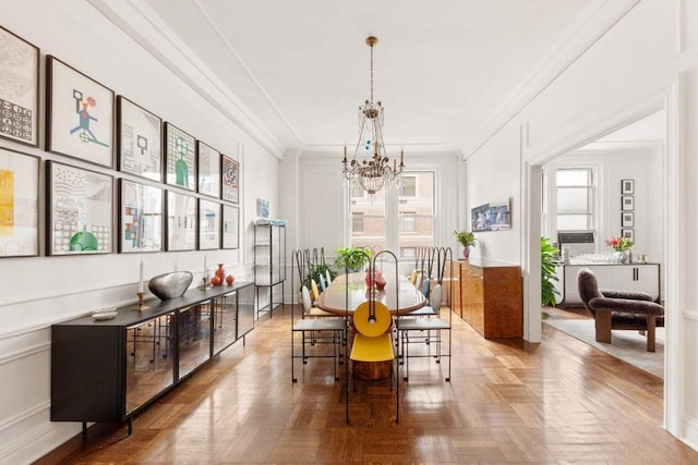 dining space featuring an inviting chandelier, parquet flooring, and crown molding