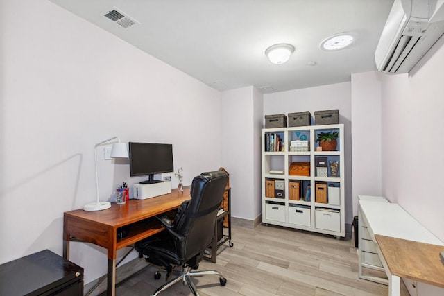 office area featuring a wall unit AC and light hardwood / wood-style flooring