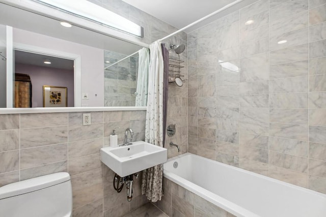 bathroom with toilet, shower / bathtub combination with curtain, and tile walls