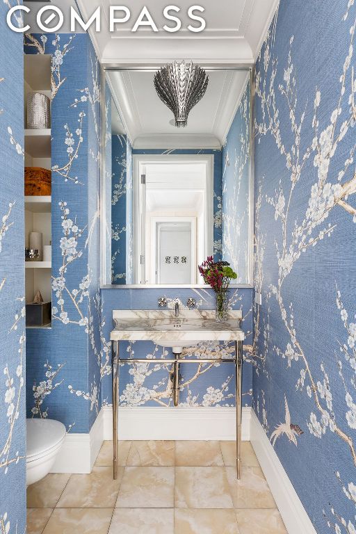 bathroom with toilet, vanity, tile patterned flooring, and crown molding