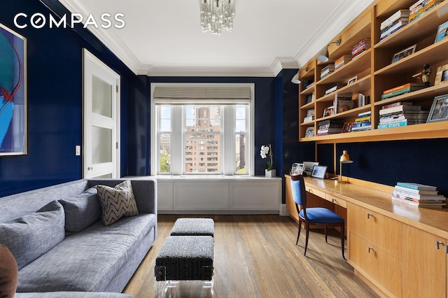 office space featuring crown molding, built in desk, and wood finished floors