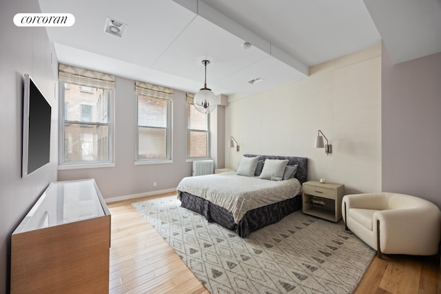 bedroom with radiator and light hardwood / wood-style flooring