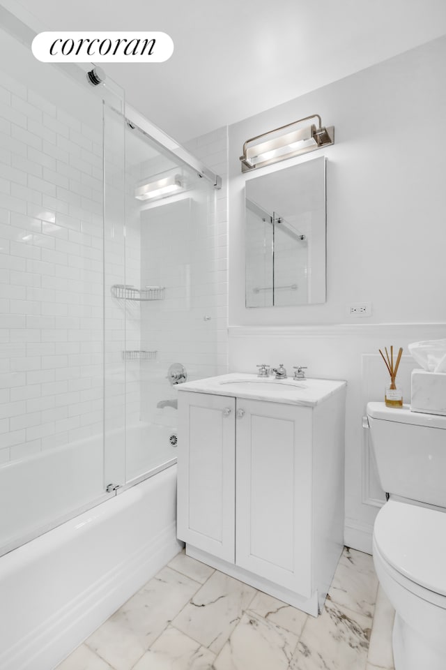 full bathroom featuring bath / shower combo with glass door, vanity, and toilet