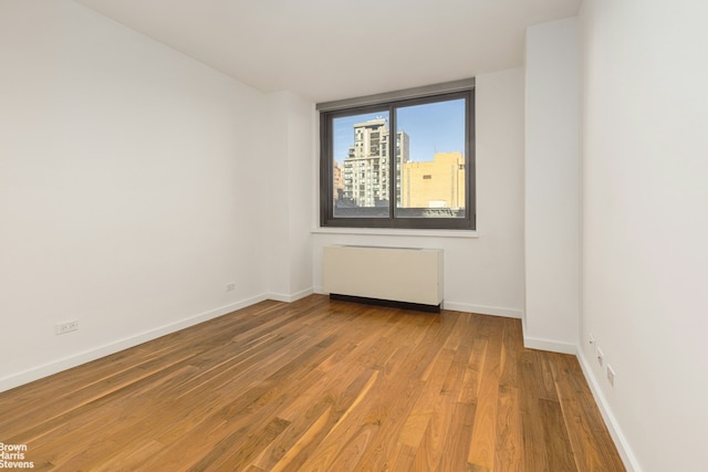 515 E 72nd St Unit 4A, New York City, NY 10021 - spare room with radiator, wood finished floors, and baseboards