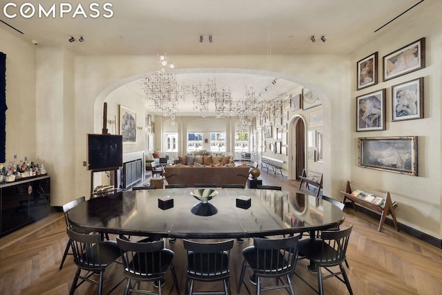 dining area featuring a notable chandelier and parquet floors